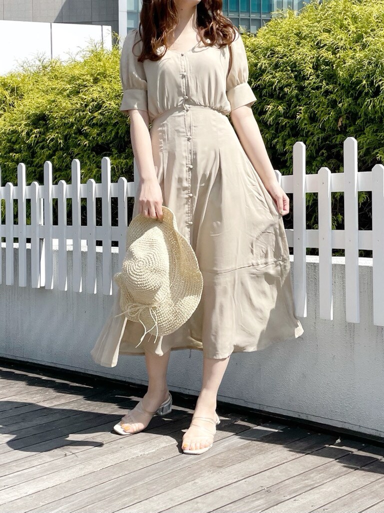 ベージュ系のワンピース、その他のサンダル、ホワイト系のハットを着用したレディースの春コーディネートの2枚目の写真