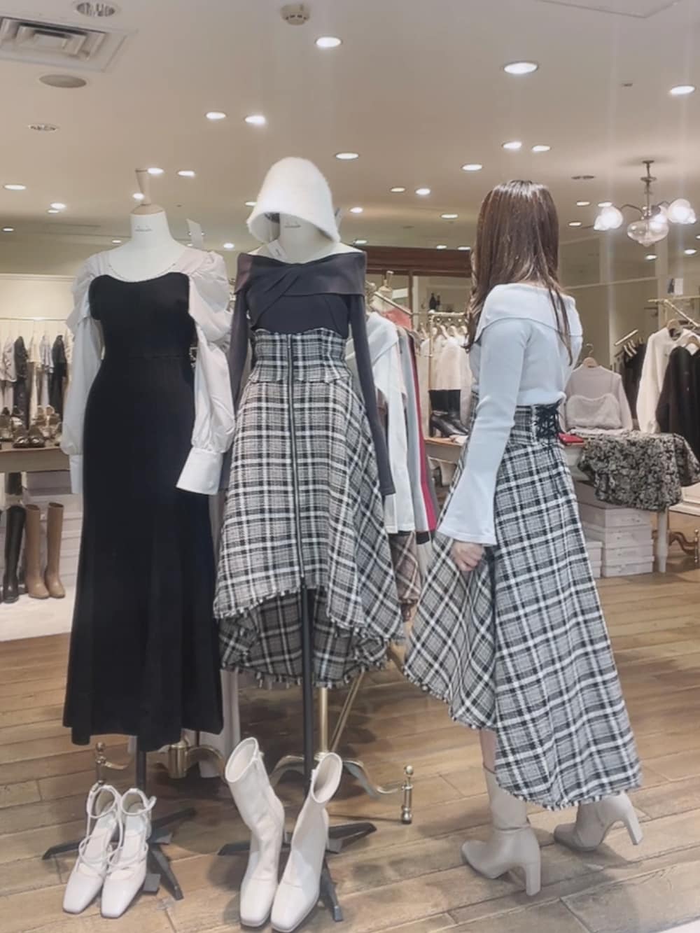 グレー系のニット/セーター、ブルー系のスカート、ホワイト系のブーツを着用したレディースの秋コーディネートの4枚目の写真