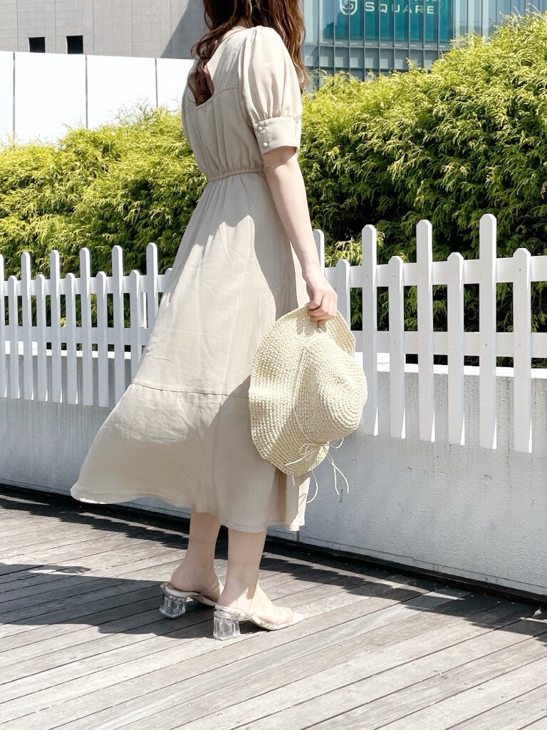 ベージュ系のワンピース、その他のサンダル、ホワイト系のハットを着用したレディースの春コーディネートの3枚目の写真