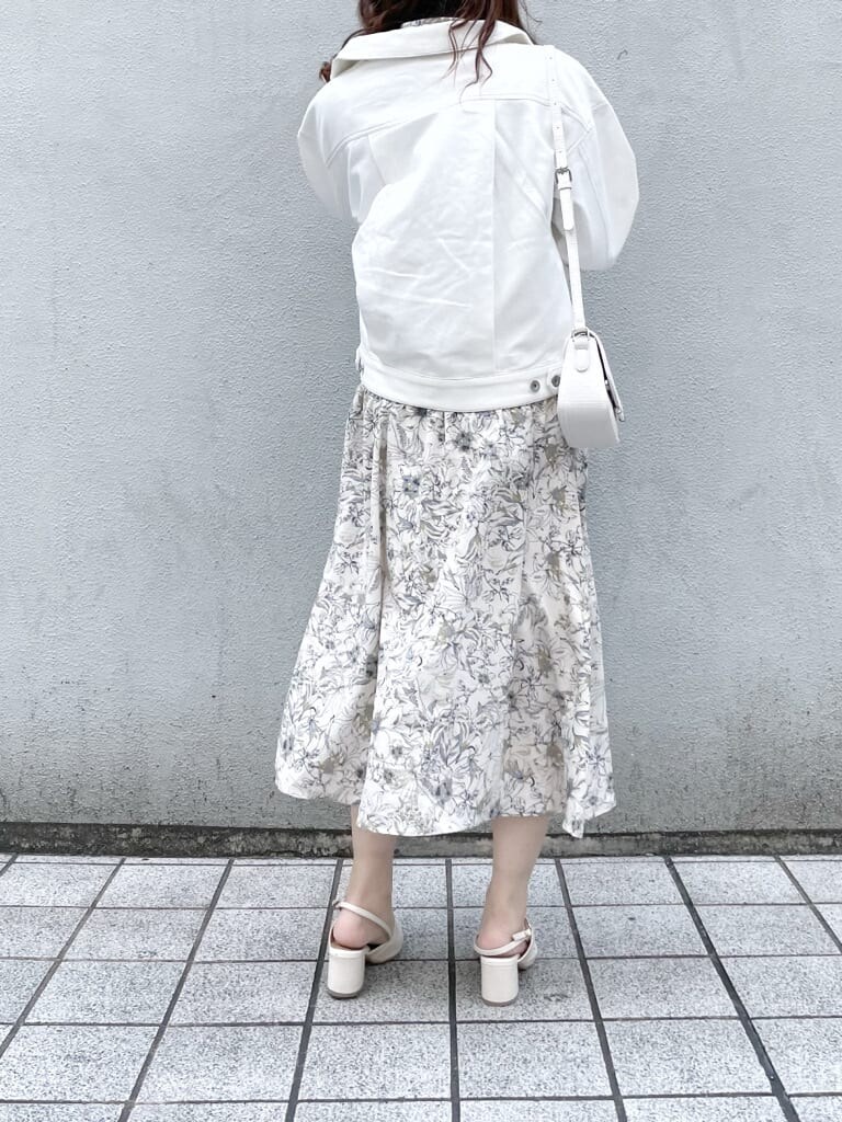 ホワイト系のデニムジャケット、ホワイト系のワンピース、ホワイト系のパンプスを着用したレディースの春コーディネートの2枚目の写真