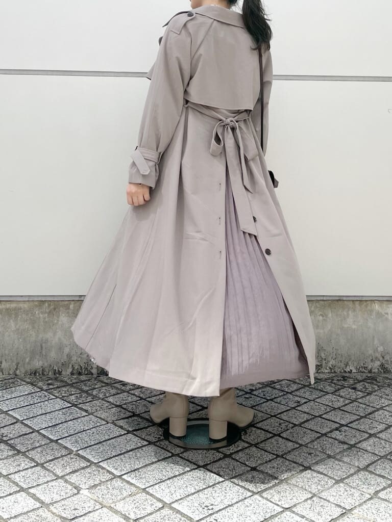 ブラウン系のワンピース、グレー系のトレンチコート、ベージュ系のブーツを着用したレディースの秋コーディネートの2枚目の写真