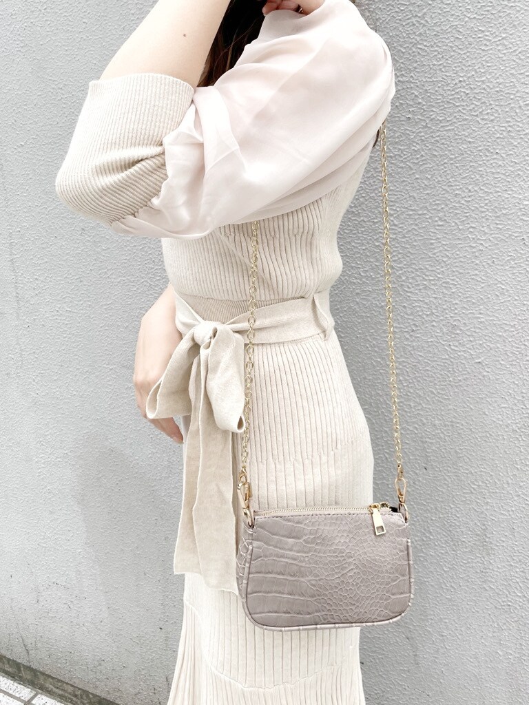 ベージュ系のワンピース、ホワイト系のパンプス、ベージュ系のショルダーバッグを着用したレディースの冬コーディネートの5枚目の写真