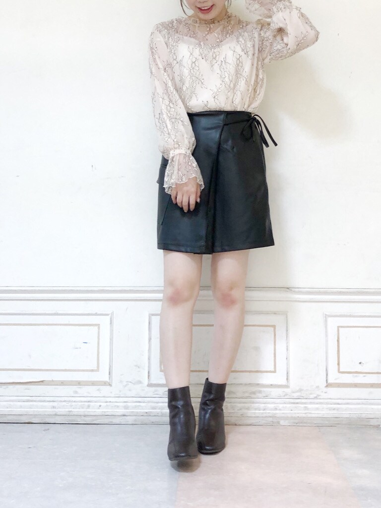 ホワイト系のシャツ/ブラウス、ブラック系のスカート、ブラウン系のブーツを着用したレディースの秋コーディネートの2枚目の写真