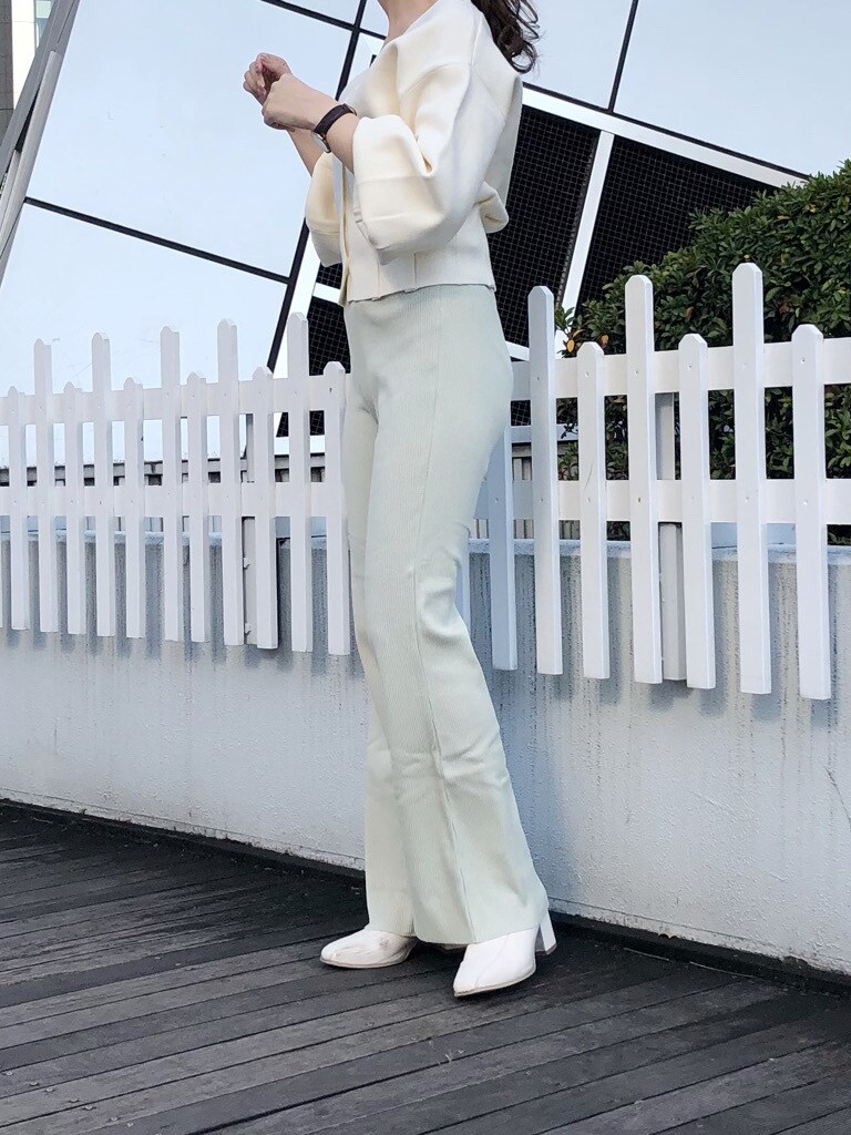 ホワイト系のブーツ、グリーン系のその他パンツ、ホワイト系のカーディガン/ボレロを着用したレディースの冬コーディネートの2枚目の写真