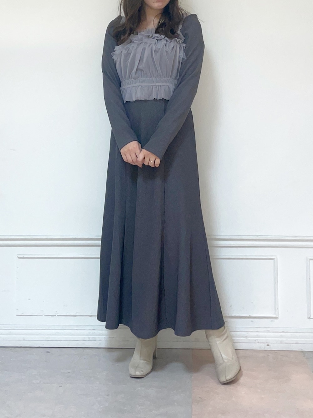 グレー系のワンピース、ホワイト系のブーツを着用したレディースの秋コーディネートの2枚目の写真