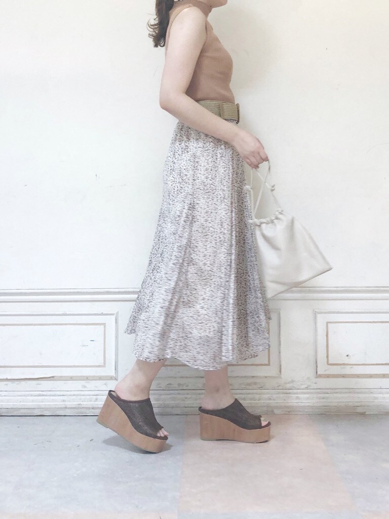 ホワイト系のハンドバッグ、ベージュ系のニット/セーター、ホワイト系のスカートを着用したレディースの夏コーディネートの2枚目の写真