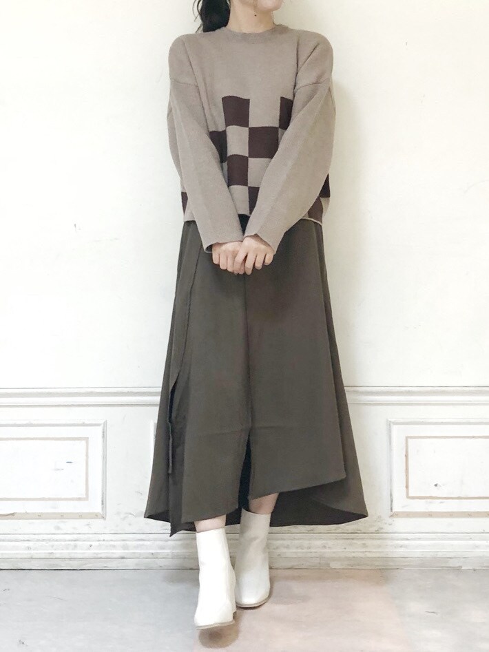 ホワイト系のブーツ、ブラウン系のスカート、ベージュ系のニット/セーターを着用したレディースの秋コーディネートの3枚目の写真