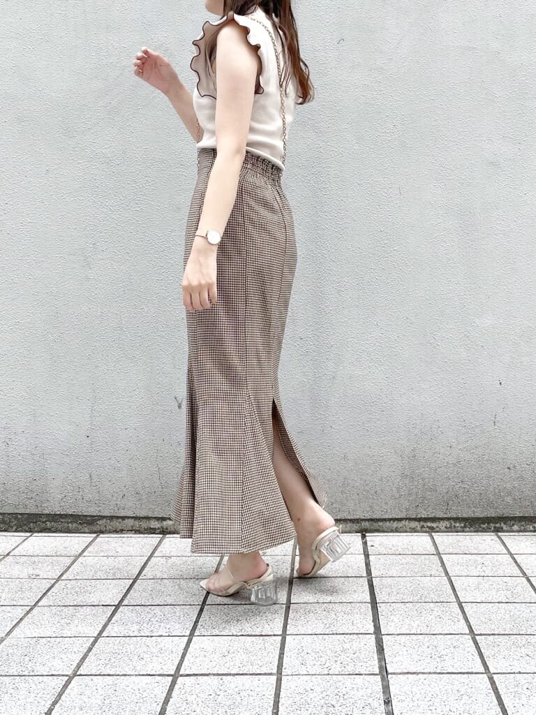 ホワイト系のショルダーバッグ、ブラウン系のスカート、その他のサンダルを着用したレディースの夏コーディネートの2枚目の写真