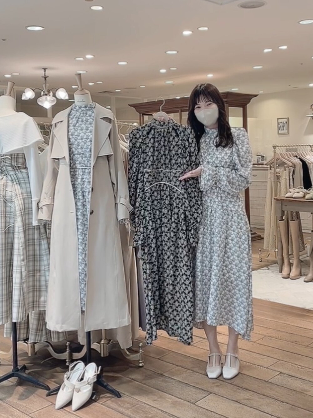 ベージュ系のトレンチコート、ホワイト系のワンピース、ホワイト系のパンプスを着用したレディースの冬コーディネートの3枚目の写真