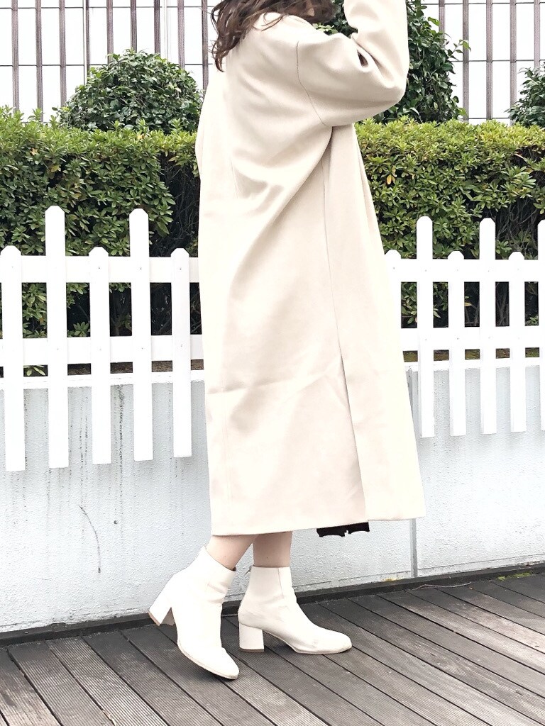 ホワイト系のブーツ、ホワイト系のその他アウター、ブラウン系のワンピースを着用したレディースの冬コーディネートの4枚目の写真