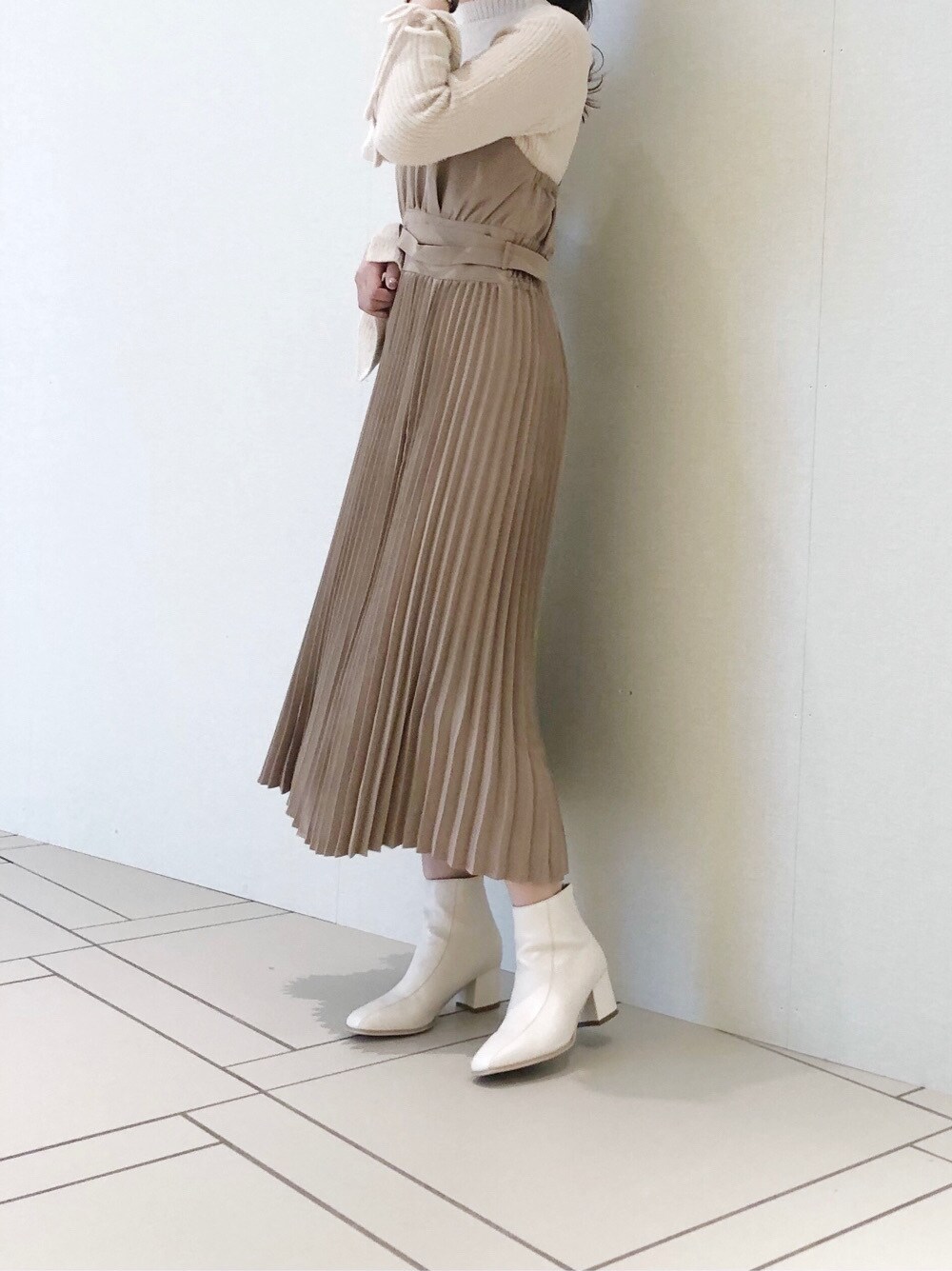 ホワイト系のブーツ、ベージュ系のワンピース、ホワイト系のニット/セーターを着用したレディースの冬コーディネートの3枚目の写真