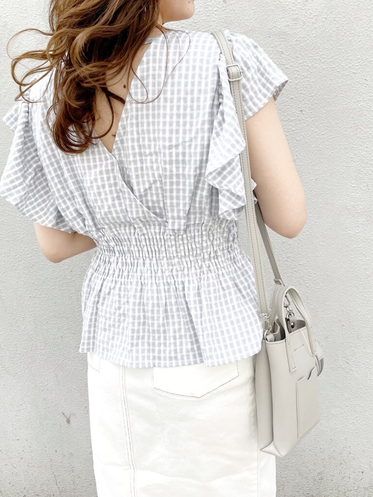 グレー系のハンドバッグ、ブルー系のシャツ/ブラウス、ホワイト系のスカートを着用したレディースの春コーディネートの2枚目の写真