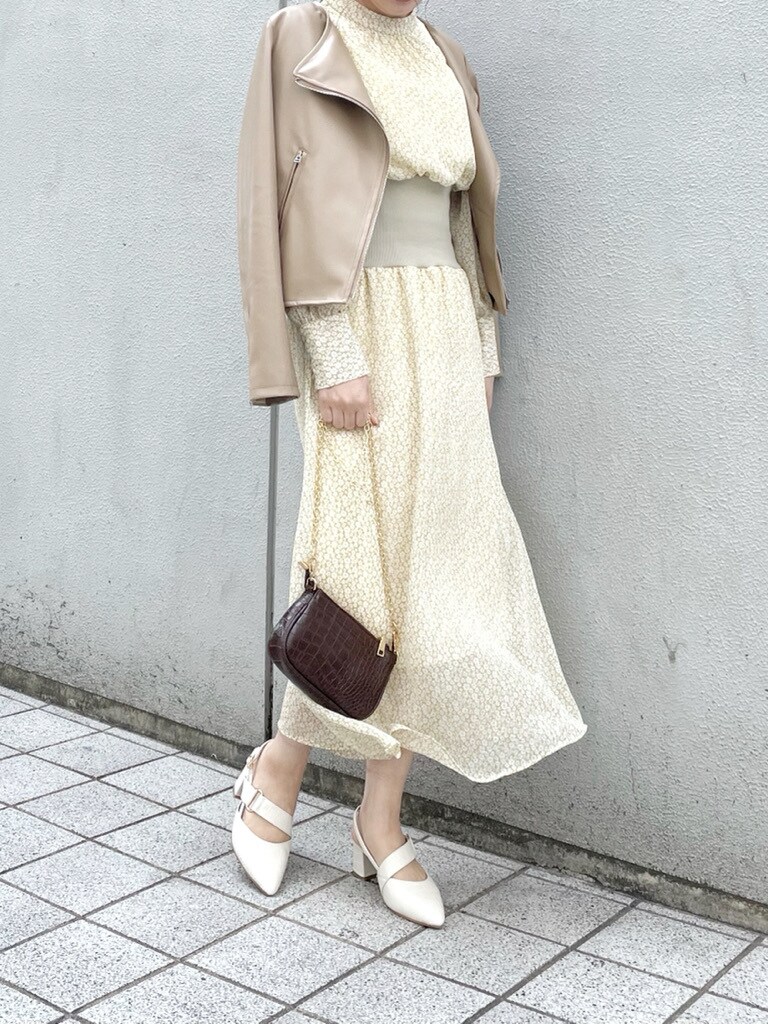 ホワイト系のパンプス、ベージュ系のライダースジャケット、ブラウン系のショルダーバッグを着用したレディースの冬コーディネートの2枚目の写真