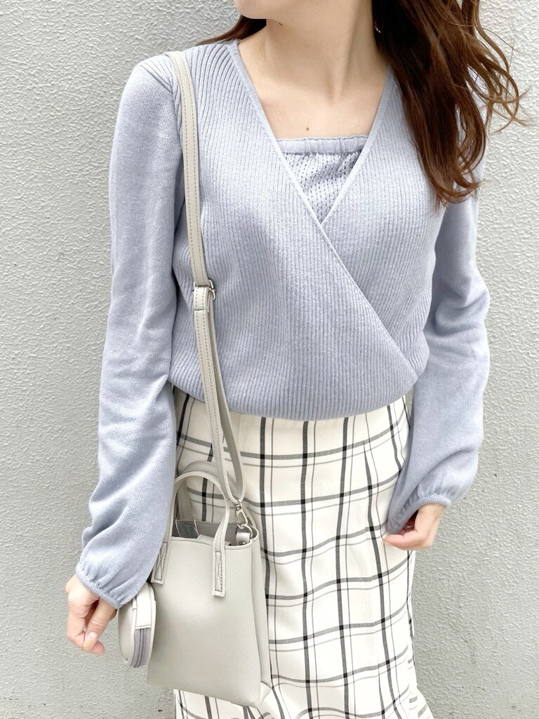 ブルー系のニット/セーター、グレー系のハンドバッグ、ホワイト系のスカートを着用したレディースの冬コーディネートの2枚目の写真