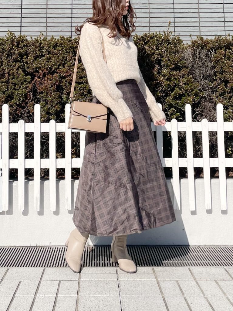 ブラウン系のスカート、ブラウン系のニット/セーター、ベージュ系のブーツを着用したレディースの冬コーディネートの2枚目の写真