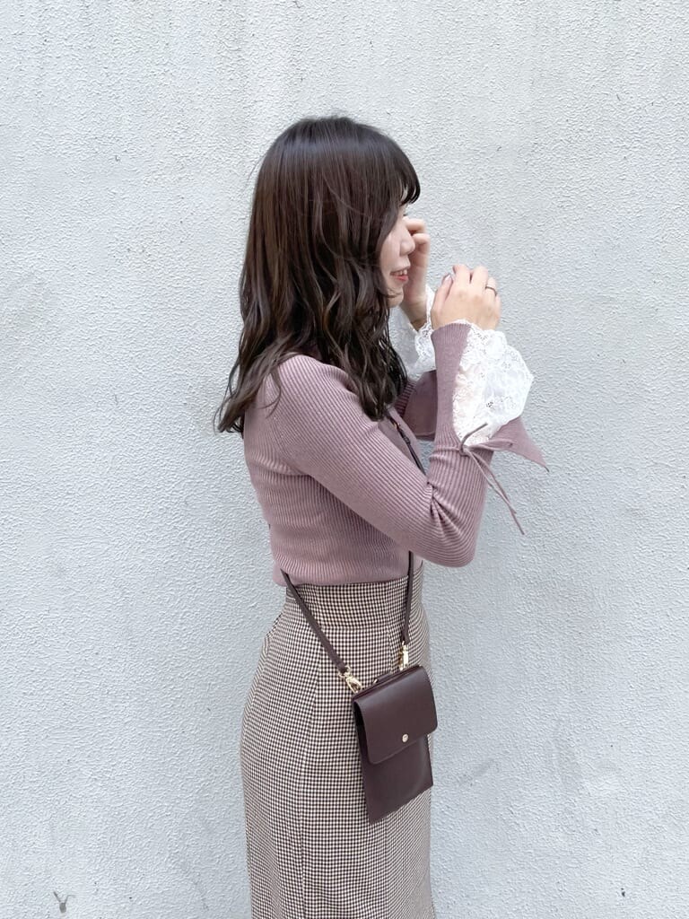 ブラウン系のスカート、ベージュ系のブーツ、ピンク系のニット/セーターを着用したレディースの秋コーディネートの5枚目の写真