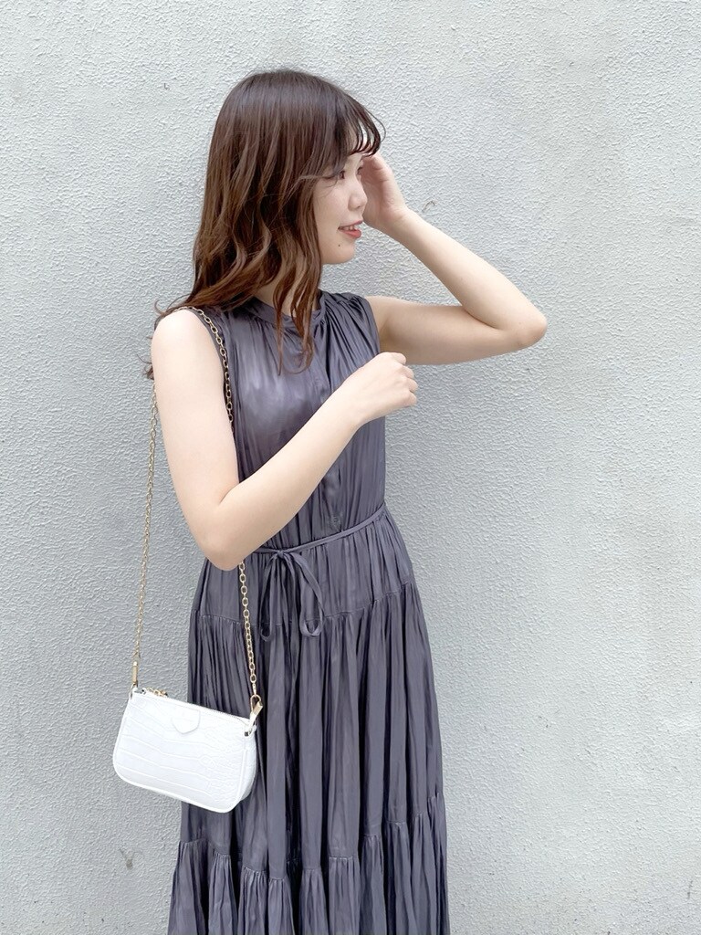 パープル系のワンピース、ホワイト系のパンプス、ホワイト系のショルダーバッグを着用したレディースの春コーディネートの3枚目の写真