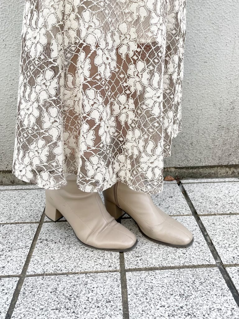 ベージュ系のスカート、ベージュ系のその他アウター、ベージュ系のハンドバッグを着用したレディースの秋コーディネートの10枚目の写真