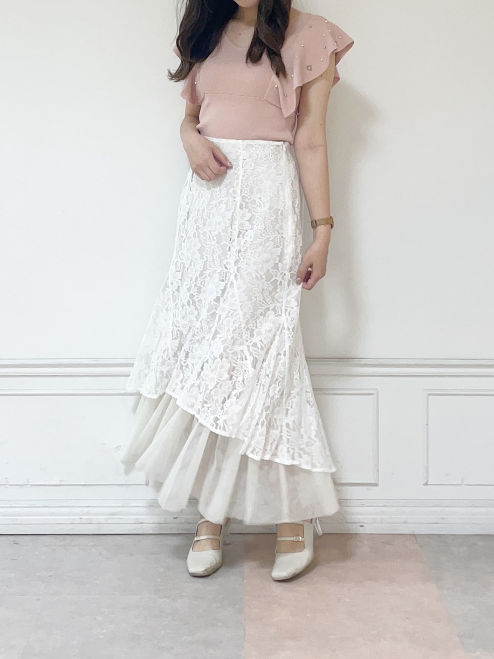 ホワイト系のスカート、ホワイト系のパンプス、ピンク系のニット/セーターを着用したレディースの春コーディネートの2枚目の写真