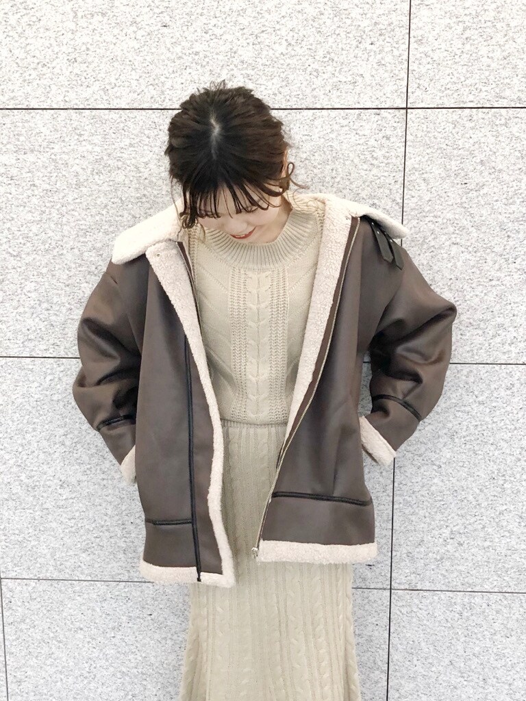 ブラウン系のブーツ、ブラウン系のブルゾン、ベージュ系のワンピースを着用したレディースの冬コーディネートの3枚目の写真