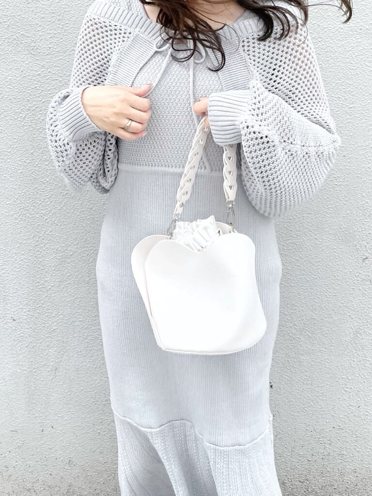 グレー系のワンピース、ホワイト系のハンドバッグ、ホワイト系のパンプスを着用したレディースの秋コーディネートの3枚目の写真