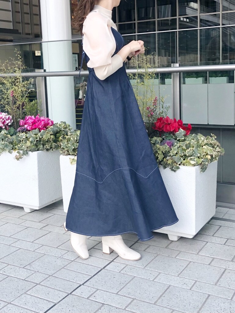 ホワイト系のブーツ、ホワイト系のニット/セーター、ブルー系のワンピースを着用したレディースの冬コーディネートの2枚目の写真