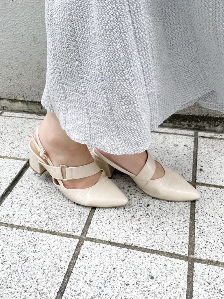 グレー系のワンピース、ホワイト系のハンドバッグ、ホワイト系のパンプスを着用したレディースの秋コーディネートの7枚目の写真