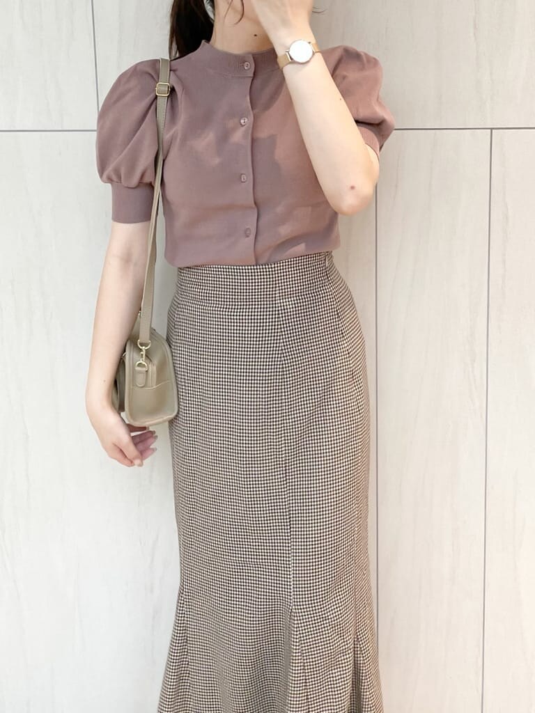 ブラウン系のスカート、ピンク系のニット/セーター、ベージュ系のハンドバッグを着用したレディースの秋コーディネートの5枚目の写真