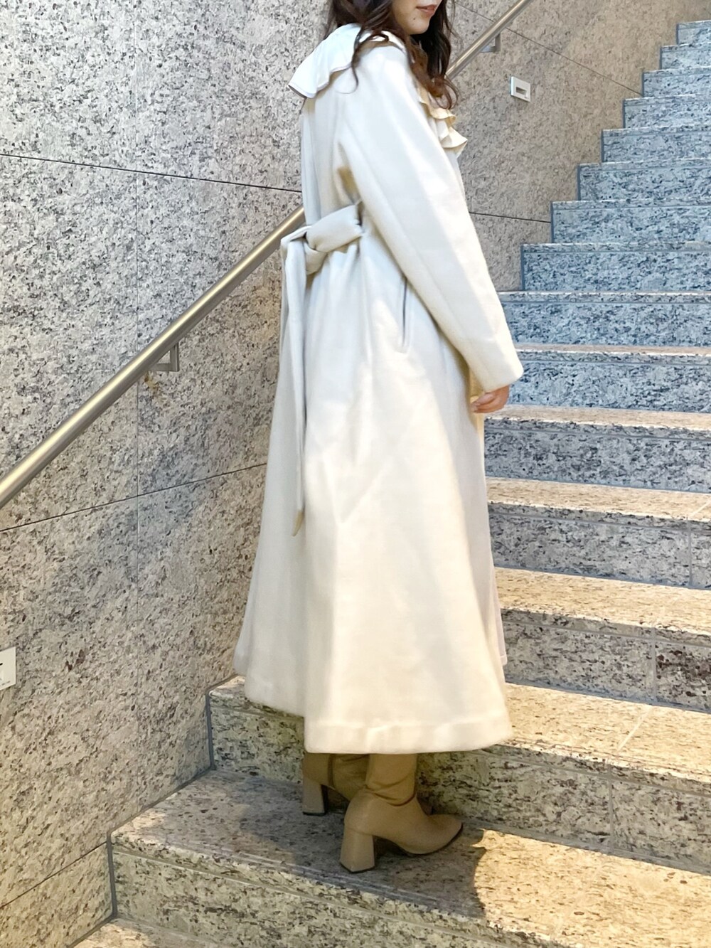 パープル系のワンピース、ホワイト系のその他アウター、ベージュ系のブーツを着用したレディースの冬コーディネートの2枚目の写真