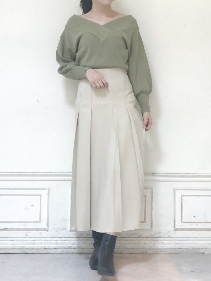 グリーン系のニット/セーター、ベージュ系のスカート、ブラウン系のブーツを着用したレディースの秋コーディネートの3枚目の写真