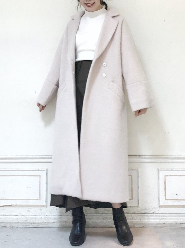 ブラウン系のブーツ、ブラウン系のスカート、ホワイト系のニット/セーターを着用したレディースの秋コーディネートの2枚目の写真