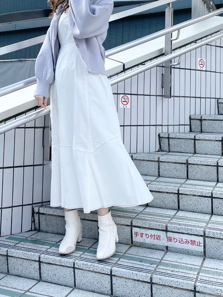 ホワイト系のブーツ、ホワイト系のワンピース、ブルー系のカーディガン/ボレロを着用したレディースの冬コーディネートの3枚目の写真