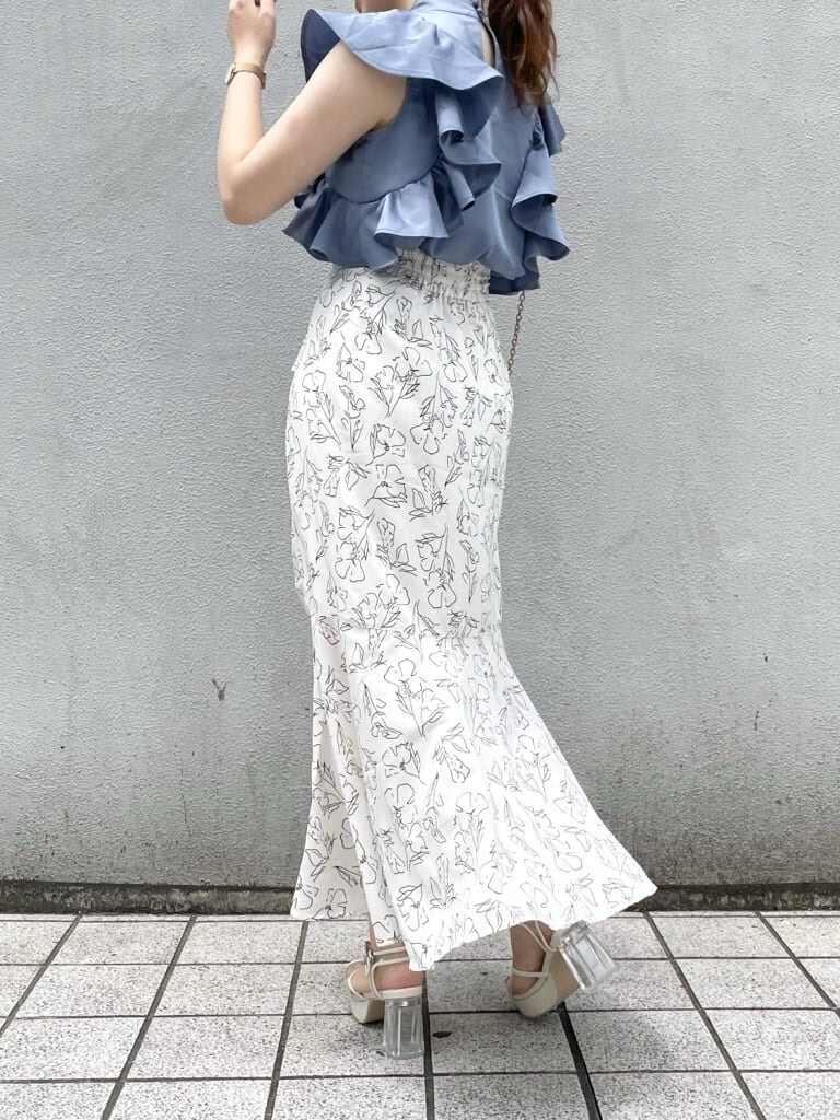 ホワイト系のサンダル、ブルー系のシャツ/ブラウス、ホワイト系のスカートを着用したレディースの夏コーディネートの2枚目の写真