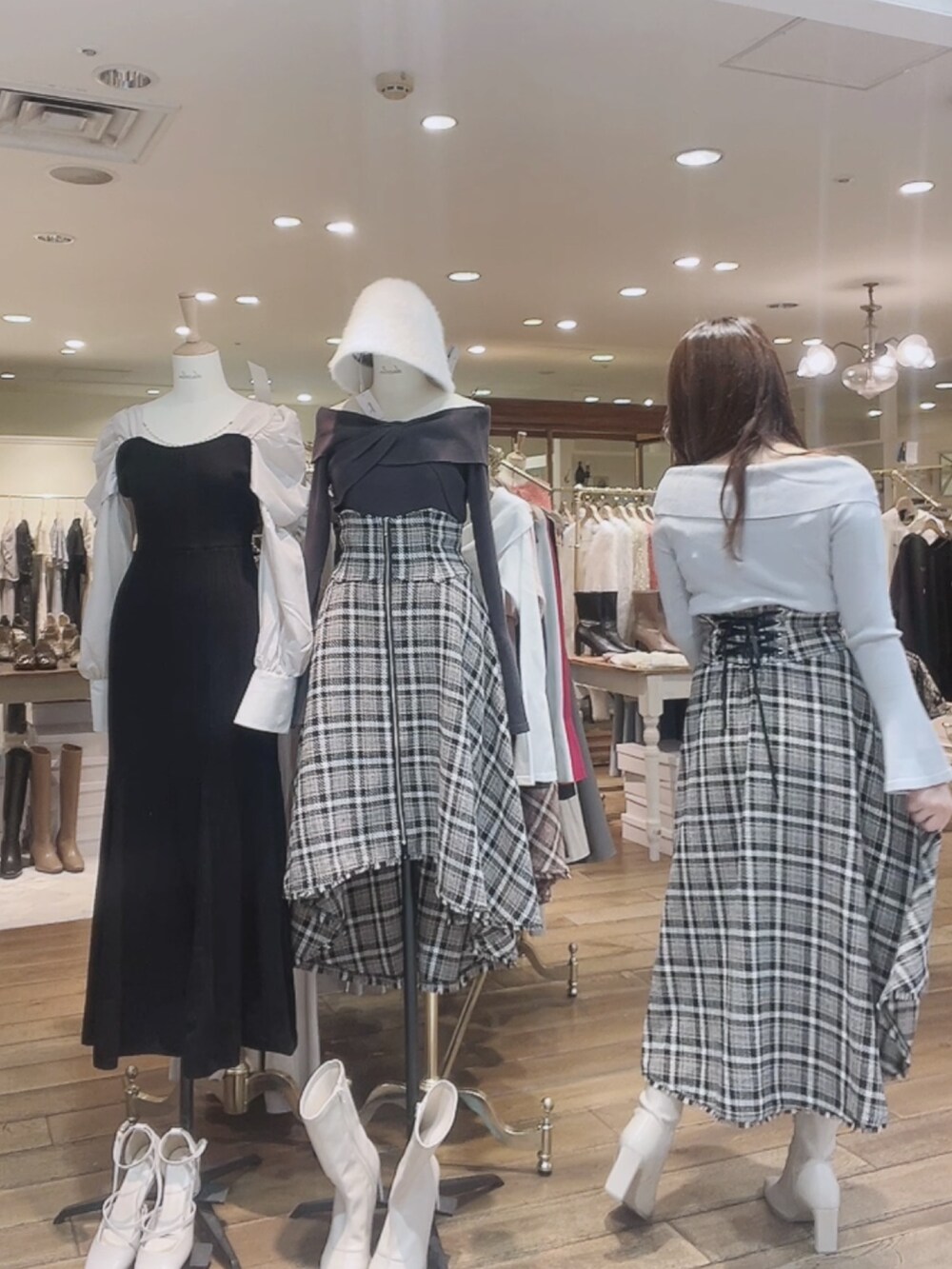 グレー系のニット/セーター、ブルー系のスカート、ホワイト系のブーツを着用したレディースの秋コーディネートの5枚目の写真