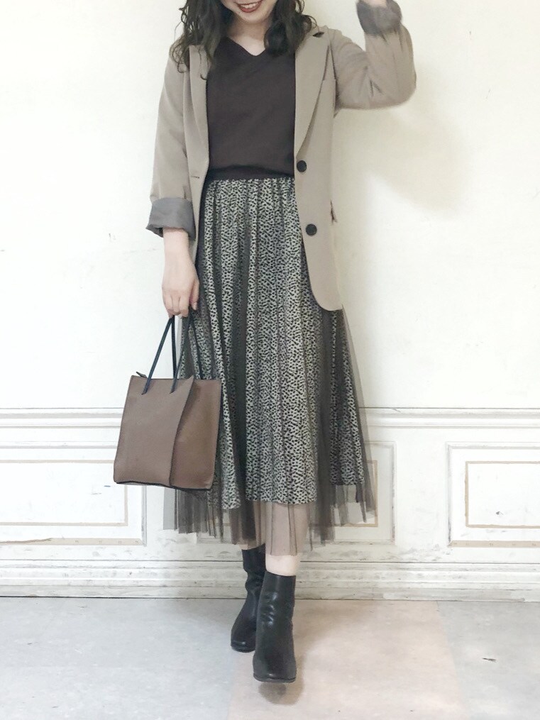 ブラウン系のブーツ、ブラウン系のスカート、ブラウン系のハンドバッグを着用したレディースの秋コーディネートの2枚目の写真