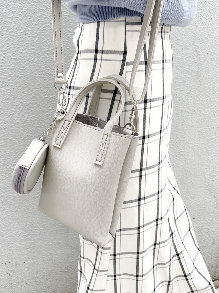 ブルー系のニット/セーター、グレー系のハンドバッグ、ホワイト系のスカートを着用したレディースの冬コーディネートの3枚目の写真