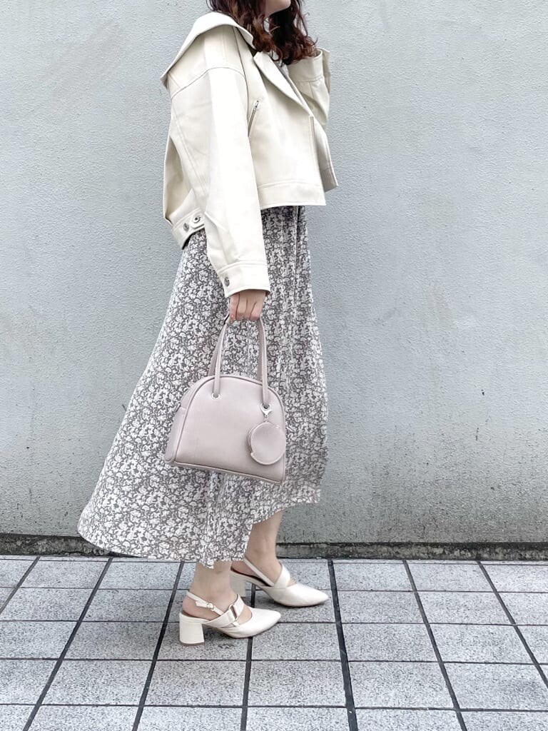 ホワイト系のワンピース、ホワイト系のライダースジャケット、ホワイト系のパンプスを着用したレディースの冬コーディネートの2枚目の写真