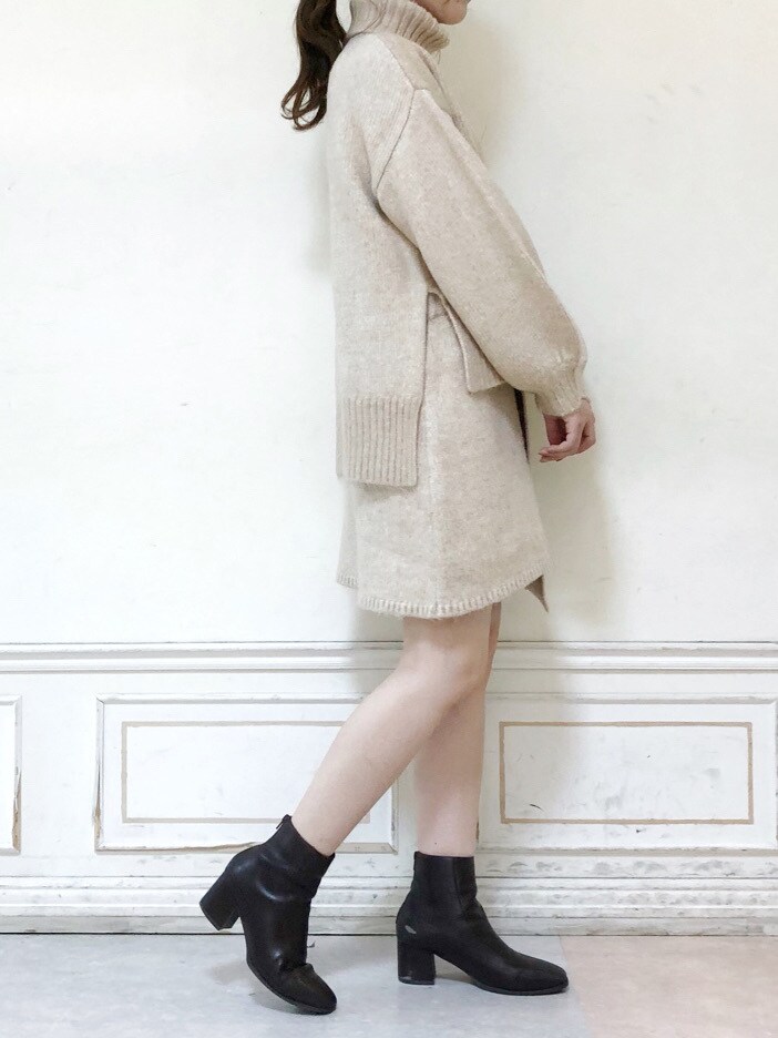 ベージュ系のスカート、ブラウン系のブーツ、ベージュ系のニット/セーターを着用したレディースの秋コーディネートの2枚目の写真