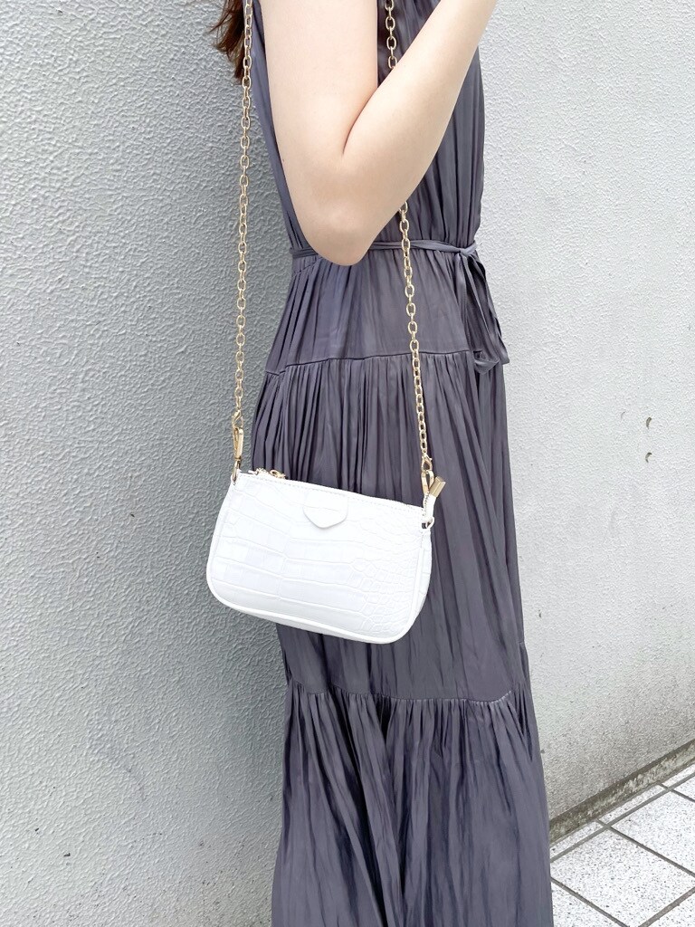 パープル系のワンピース、ホワイト系のパンプス、ホワイト系のショルダーバッグを着用したレディースの春コーディネートの5枚目の写真