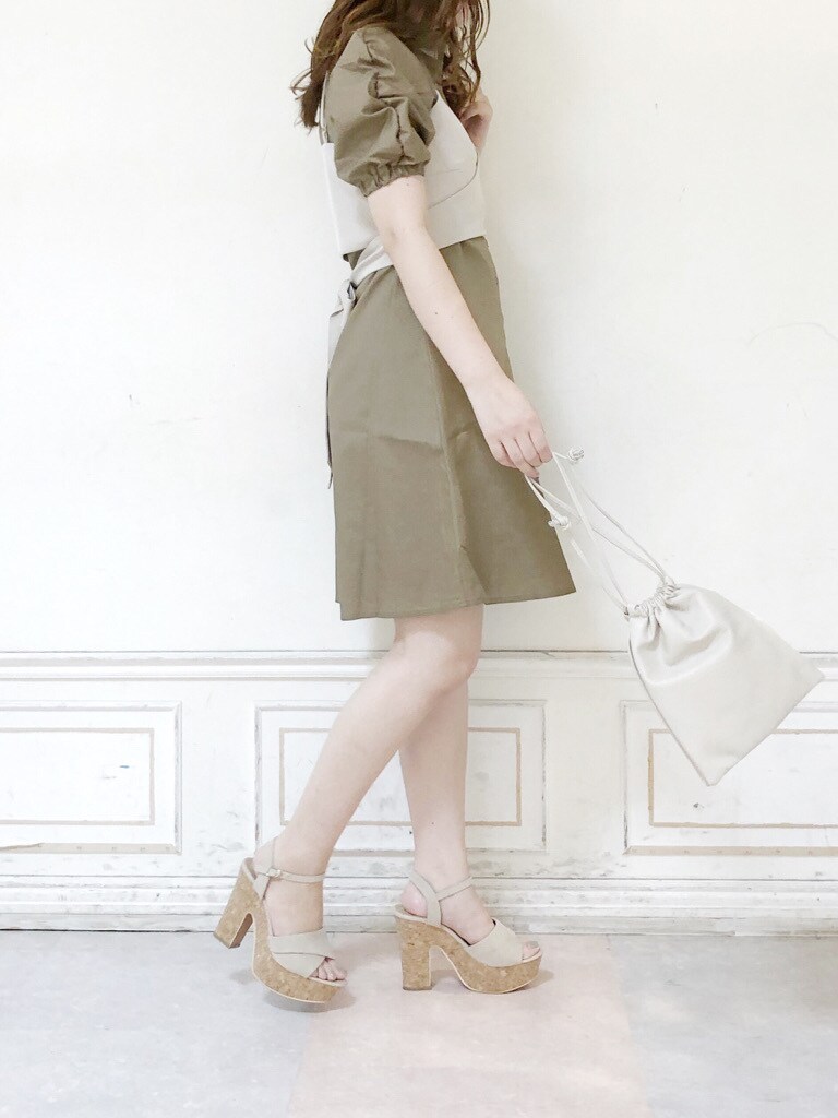 ブラウン系のワンピース、ホワイト系のハンドバッグ、ベージュ系のサンダルを着用したレディースの夏コーディネートの2枚目の写真