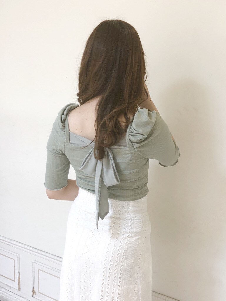 ホワイト系のテーラードジャケット、ホワイト系のスカート、ベージュ系のハンドバッグを着用したレディースの春コーディネートの3枚目の写真