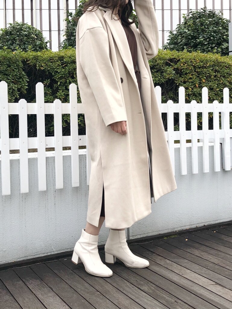 ホワイト系のブーツ、ホワイト系のその他アウター、ブラウン系のワンピースを着用したレディースの冬コーディネートの2枚目の写真