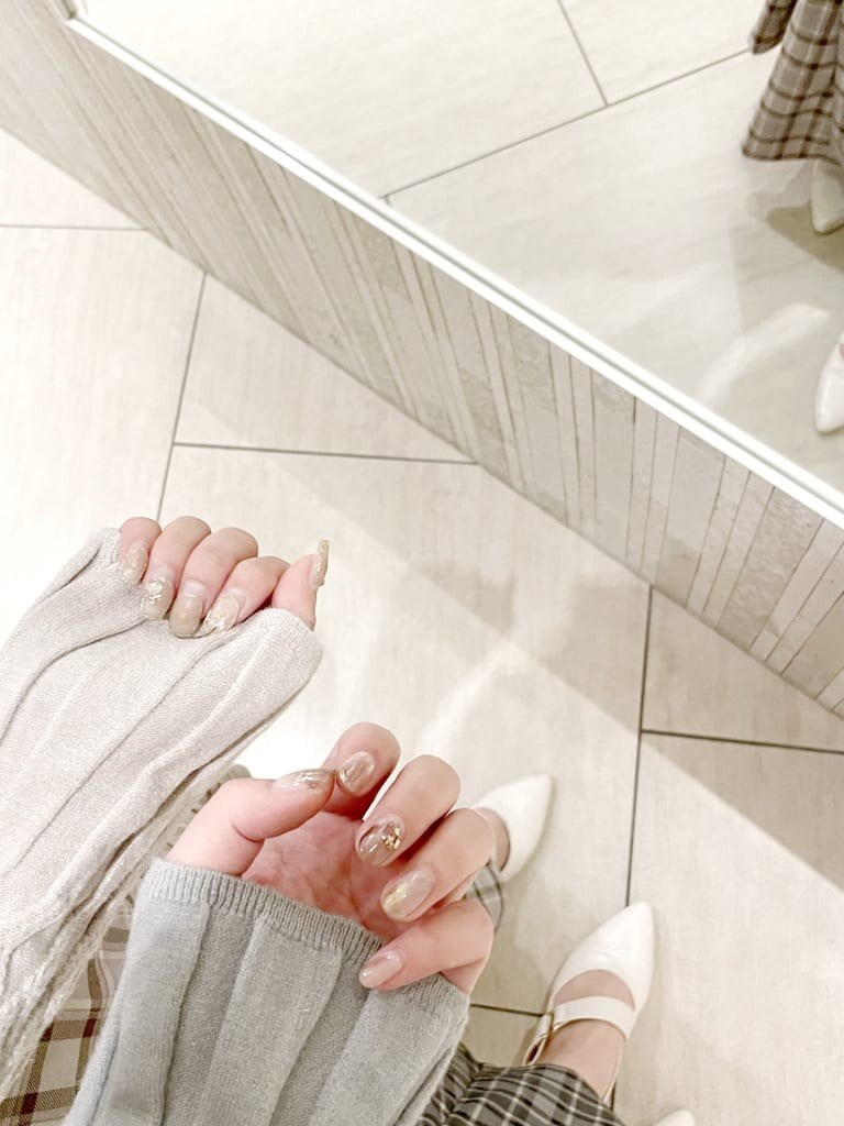 ブラック系のスカート、グレー系のスカート、ホワイト系のパンプスを着用したレディースの冬コーディネートの2枚目の写真