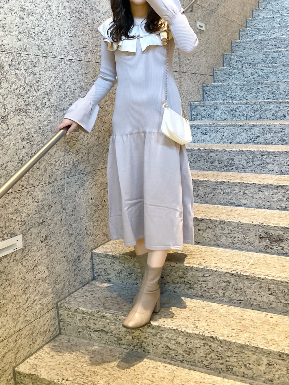 パープル系のワンピース、ホワイト系のその他アウター、ベージュ系のブーツを着用したレディースの冬コーディネートの3枚目の写真