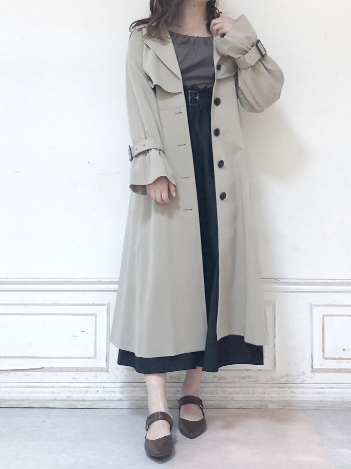 ベージュ系のトレンチコート、ブラウン系のパンプス、ブラウン系のワンピースを着用したレディースの秋コーディネートの2枚目の写真