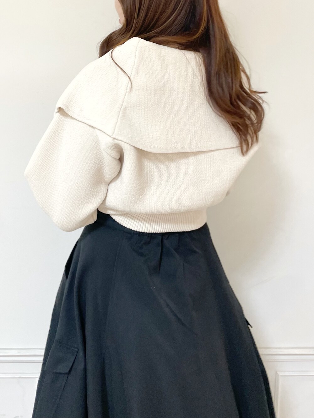 ホワイト系のニット/セーター、ブラック系のスカート、ホワイト系のブーツを着用したレディースの秋コーディネートの5枚目の写真