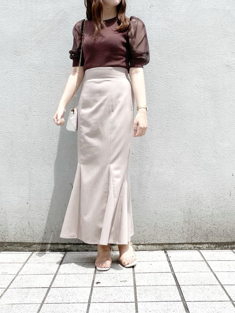 ホワイト系のショルダーバッグ、ブラウン系のスカート、その他のサンダルを着用したレディースの夏コーディネートの2枚目の写真