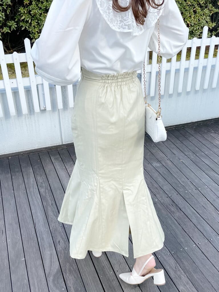 ホワイト系のシャツ/ブラウス、グリーン系のスカート、ホワイト系のパンプスを着用したレディースの春コーディネートの3枚目の写真