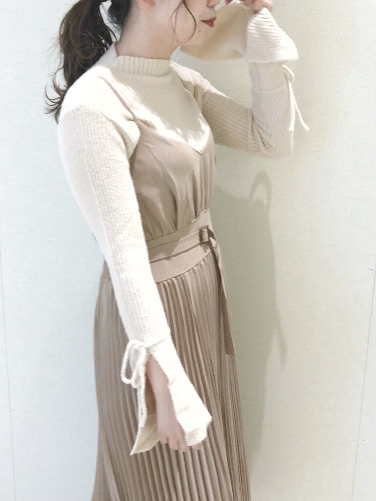 ホワイト系のブーツ、ベージュ系のワンピース、ホワイト系のニット/セーターを着用したレディースの冬コーディネートの2枚目の写真