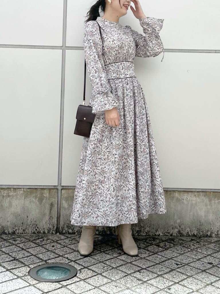 ブラウン系のワンピース、グレー系のトレンチコート、ベージュ系のブーツを着用したレディースの秋コーディネートの6枚目の写真